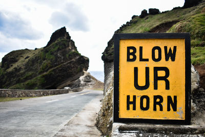 Close-up of road sign against mountain