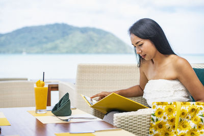 Woman checking the menu at restaurant in luxury resort in phuket