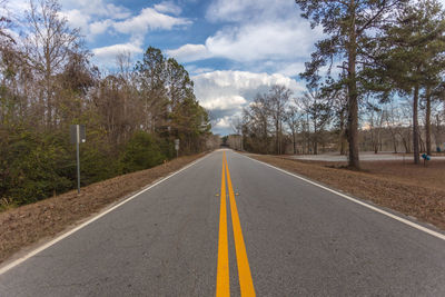 Road amidst trees against sky