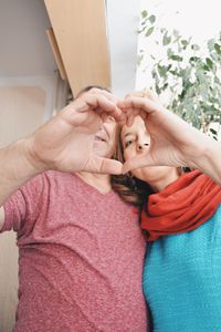 Mature couple making heart shape