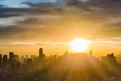 Buildings in city against sky during sunset