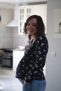 Portrait of a smiling young woman standing at home