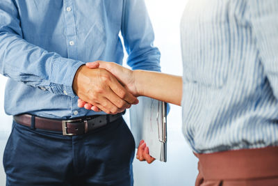 Midsection of couple holding hands