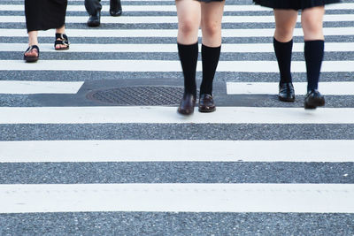 Low section of people walking on zebra crossing