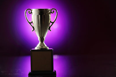 Close-up of trophy against purple light