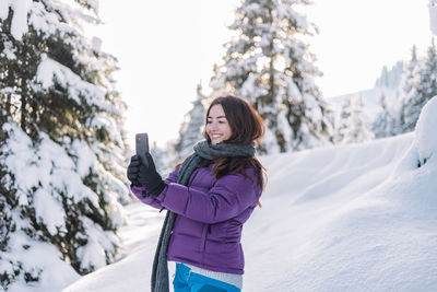 Young woman standing on snow covered field