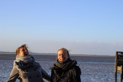 Portrait of smiling young woman in sea against sky