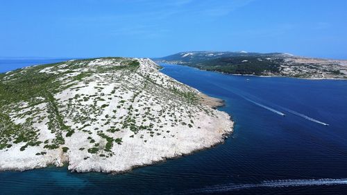 High angle view of sea shore against blue sky