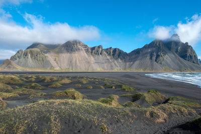 Scenic view of land and mountains against sky