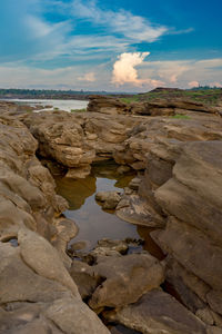 Rock formations by sea against sky