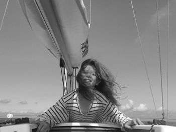 Low angle view of woman sitting on boat against sky
