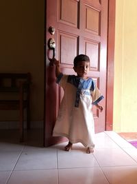 Full length of child standing on door at home