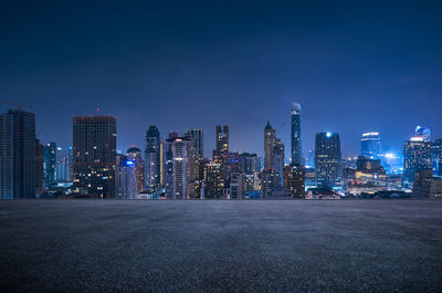 Illuminated buildings in city against sky at night