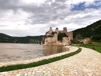 Historic building by lake against sky