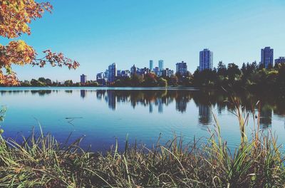 Scenic view of city by trees against blue sky