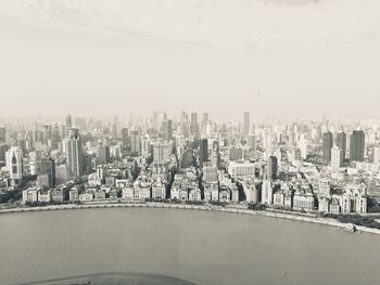 Aerial view of buildings in city against sky