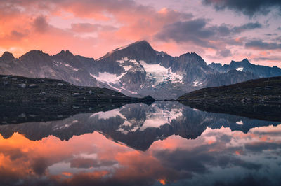 Scenic view of lake and mountains against sky during sunset