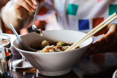 Close-up of hand holding spoon  in bowl