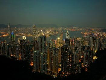 Illuminated cityscape against sky at night