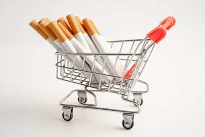 High angle view of miniature shopping cart against white background