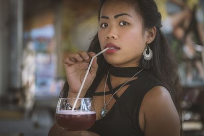 Portrait of young woman drinking glass