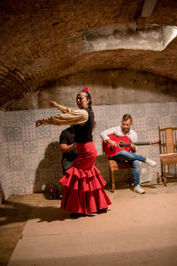 Young woman dancing on wall