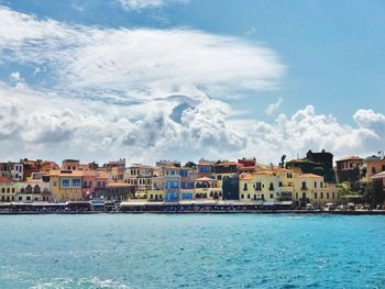 Scenic view of sea by houses against sky