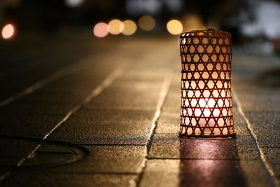 Illuminated lamp on footpath at night