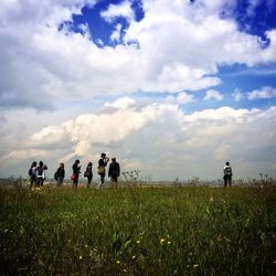 Scenic view of grassy field against cloudy sky