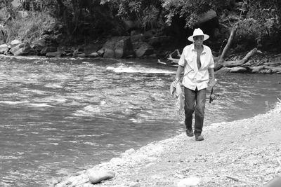 Portrait of fisherman with rods walking at beach