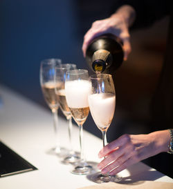 Midsection of person pouring wine in glass