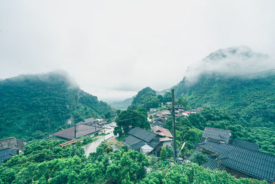 High angle view of houses and trees against sky