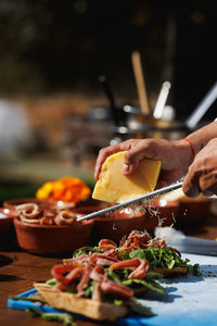 Cropped hand of man holding food on table