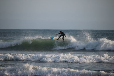 Man surfing in sea against clear sky