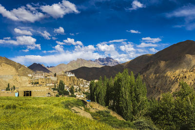 Scenic view of houses and mountains against sky