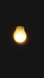 Low angle view of illuminated lamp against dark sky