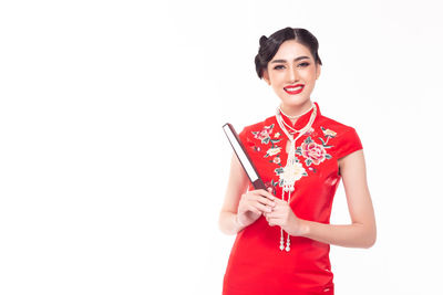 Portrait of a smiling young woman against white background