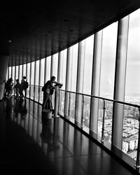 People walking in building seen through glass window