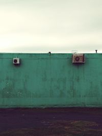 Low angle view of air conditioners on wall against sky