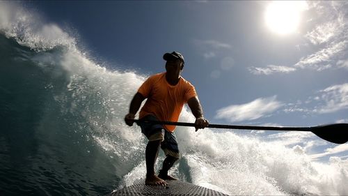 Full length of man surfing in sea against sky