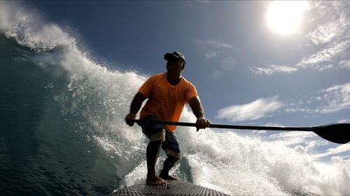 Man surfing on sea against sky