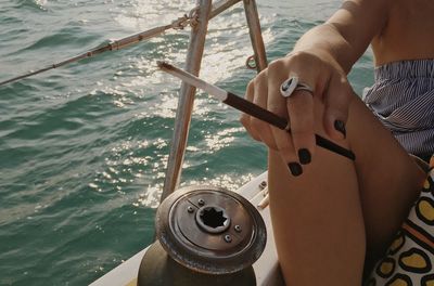 Low section of man sailing on sea