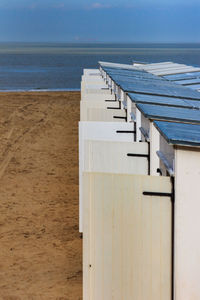 Beach huts by sea against sky