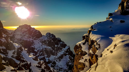 Scenic view of snowcapped mountains against sky during sunset