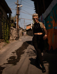 Portrait of young woman standing on road