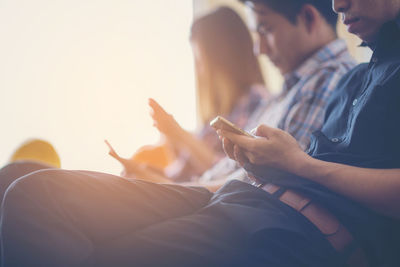 Midsection of man using mobile phone