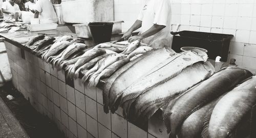 Midsection of man selling fish at market