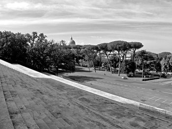 View of trees by building against sky