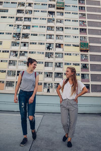 Full length of smiling young woman in city