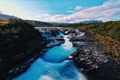 Scenic view of river amidst mountains against sky